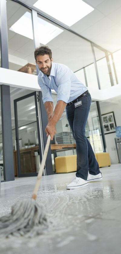 Full length shot of a young man cleaning the floors in an office